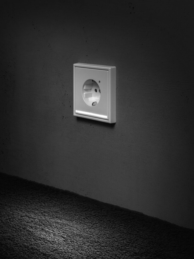 Projet d'installation électrique (prise de courant design sur mur sombre), réalisé par PRO BAT-IM, à Val-de-Marne.