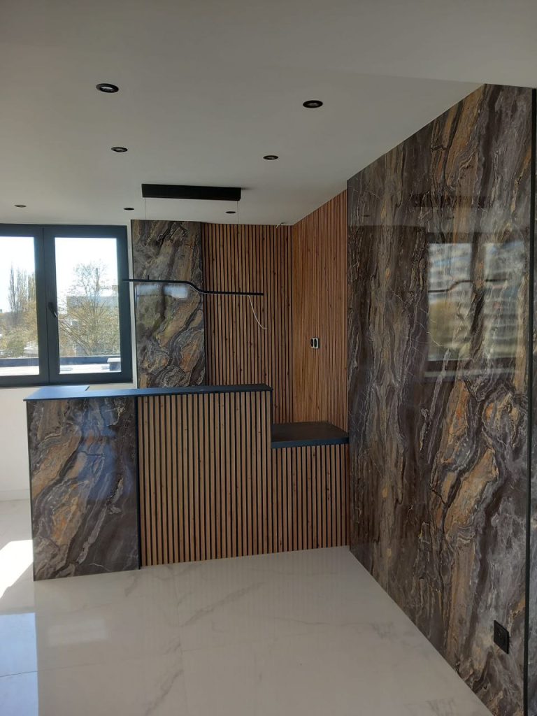 Projet de rénovation de cuisine (bar effet marbre foncé et panneaux en tasseaux de bois), réalisé par PRO BAT-IM, à Val-de-Marne.