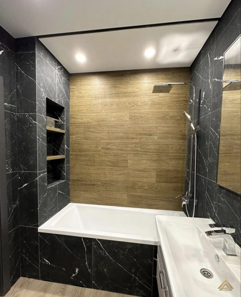 Projet de rénovation de salle de bain (carrelage effet marbre noir, carrelage effet bois et niche murale), réalisé par PRO BAT-IM, à Val-de-Marne.