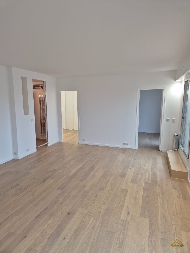 Projet de rénovation d'appartement (salon avec parquet et murs blancs, vue sur salle de bain), réalisé par PRO BAT-IM, à Val-de-Marne.
