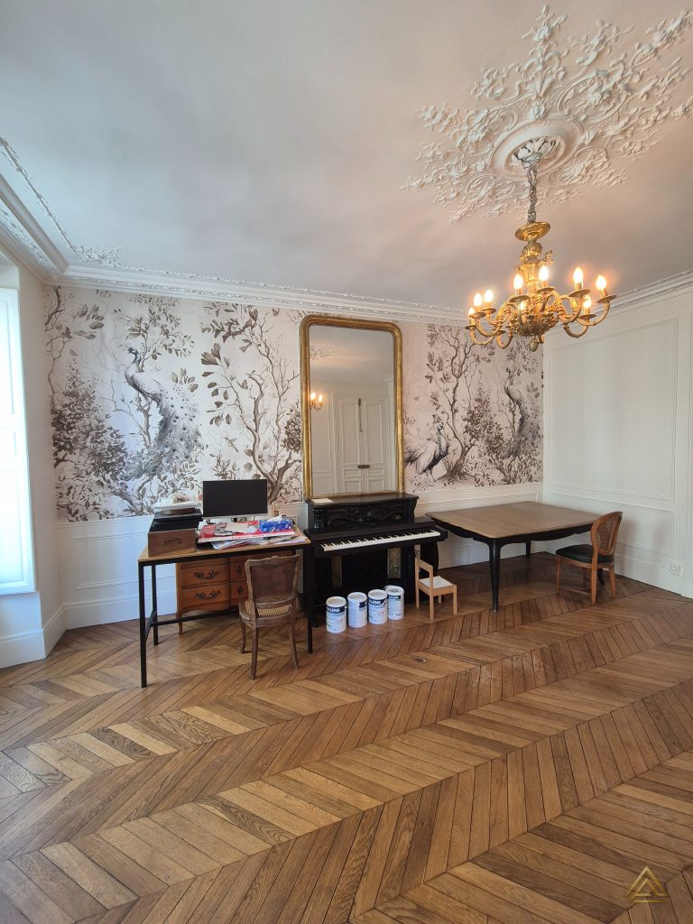 Projet de rénovation de salon (parquet chevron, boiseries et papier peint panoramique), réalisé par PRO BAT-IM, à Val-de-Marne.