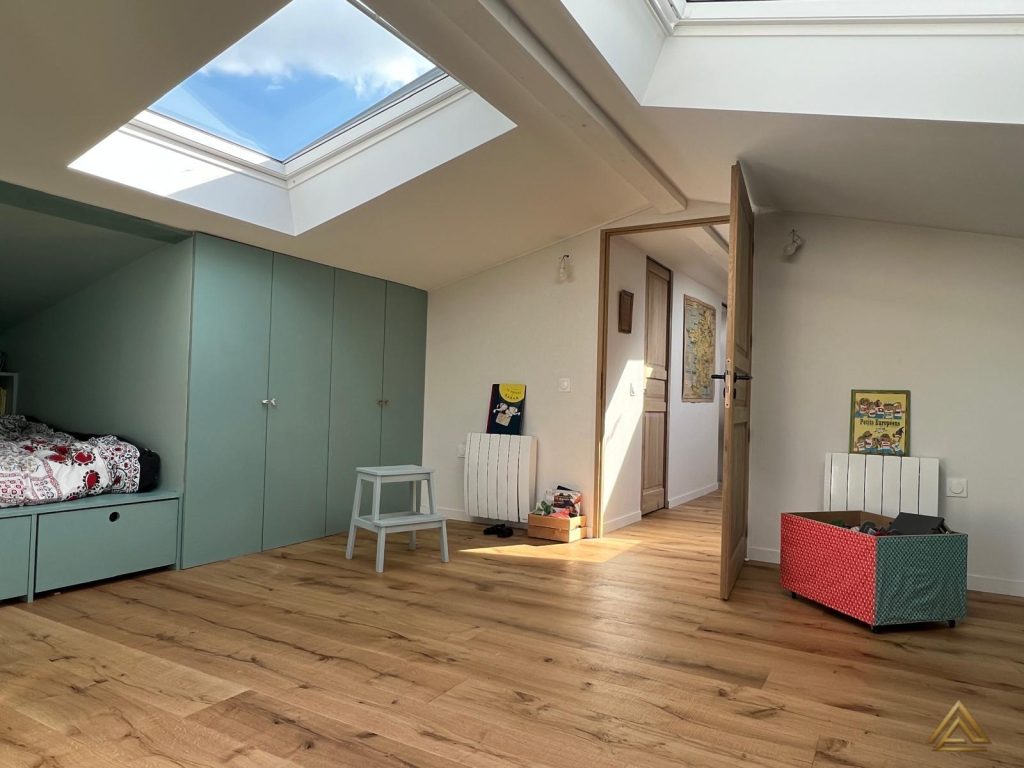 Aménagement d'un grenier en chambre (mobilier sur mesure vert d'eau et parquet), un projet PRO BAT-IM à Val-de-Marne.