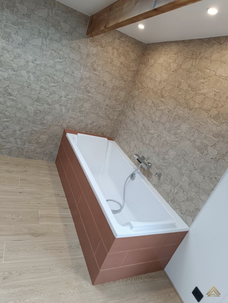 Projet de rénovation de salle de bain (baignoire avec tablier terre cuite et mur effet pierre), réalisé par PRO BAT-IM, à Val-de-Marne.
